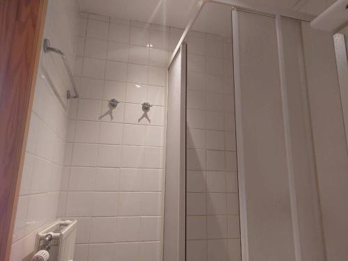 a bathroom with a shower with two hangers at Charming 1-Bedroom Apartment in Brussels