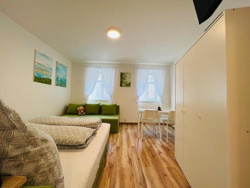 a living room with a green couch and a table at Bezbariérové apartmány se zahrádkou in Chrastava