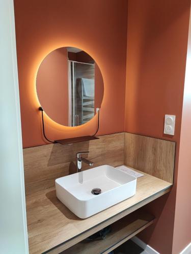 a bathroom with a white sink and a mirror at Refuge au coeur des Vosges in Aumontzey