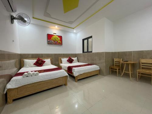 頭頓的住宿－Hotel Hoàng Phúc，一间卧室配有两张床和一张桌子及椅子