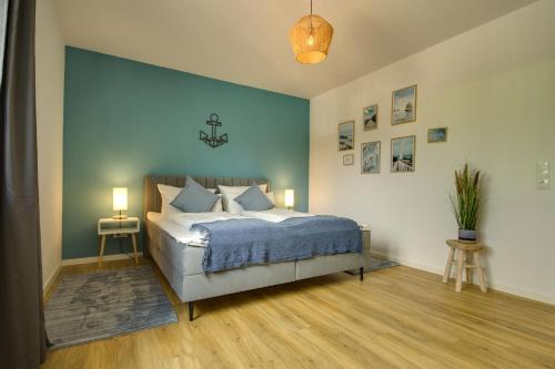 新城荷斯坦的住宿－Zentrale und komfortable "Küsten-Residenz"，一间卧室设有一张床和蓝色的墙壁