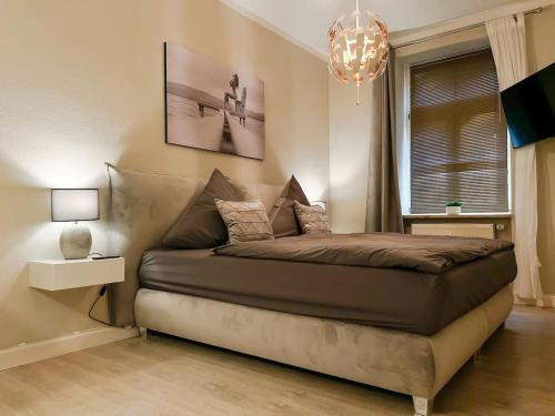 1 dormitorio con cama y lámpara de araña en Weimar 3-Raum Appartement, en Weimar