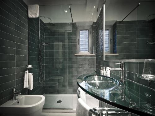 bagno con lavabo in vetro e vasca di All Time Relais & Sport Hotel a Roma