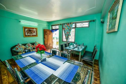 una sala da pranzo con tavolo e divano di GRG Tharbaling Homestay Darjeeling a Ghum