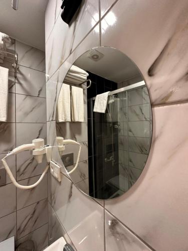 HARRAN HOTEL في إسطنبول: حمام مع مرآة ومغسلة