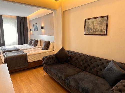 HARRAN HOTEL في إسطنبول: غرفة معيشة مع أريكة وسرير