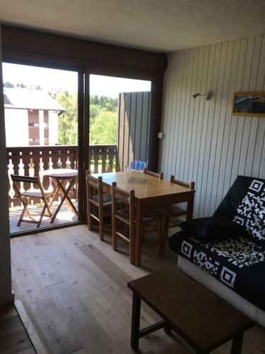 d'un salon avec une table et un canapé ainsi que d'un balcon. dans l'établissement Studio très lumineux 4 pers, aux Carroz d'Arâches