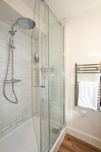 a bathroom with a shower with a glass door at 30 Chipping Norton - Luxury Holiday Apartments in Chipping Norton