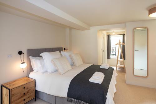 a bedroom with a large bed and a mirror at 30 Chipping Norton - Luxury Holiday Apartments in Chipping Norton