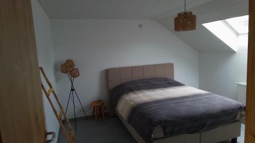 a bedroom with a bed in a white room at La Ferme Villa 2 in Bastogne