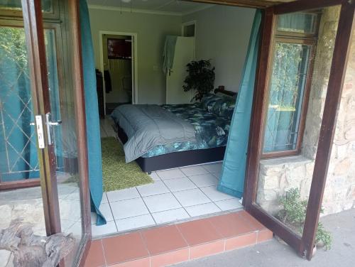 a bedroom with a bed and a glass doorway at Casa Ariel - River Lodge in Port Edward