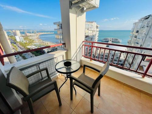 balcón con 2 sillas, mesa y vistas al océano en Like my home apartment, en Durrës