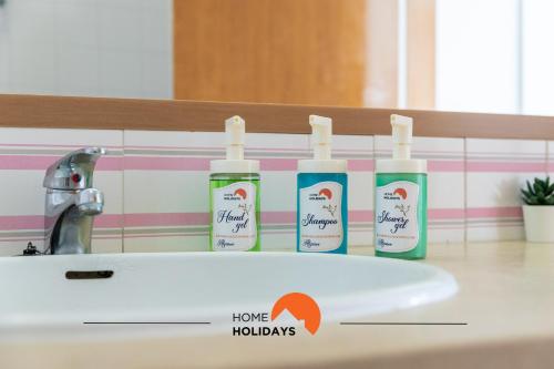 ein Waschbecken mit vier Flaschen Honighudys drauf in der Unterkunft #189 Montechoro Flat by Home Holidays in Vale de Pedras