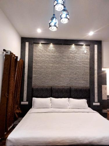 a bedroom with a large bed with white sheets at HillTop in greany meadows yercaud in Yercaud