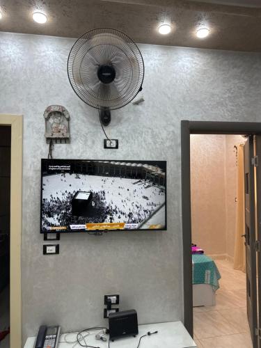 een flatscreen-tv aan een muur met een ventilator bij قويسنا محافظة المنوفيه 