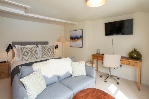 a bedroom with a bed and a couch and a desk at 30 Chipping Norton - Luxury Holiday Apartments in Chipping Norton