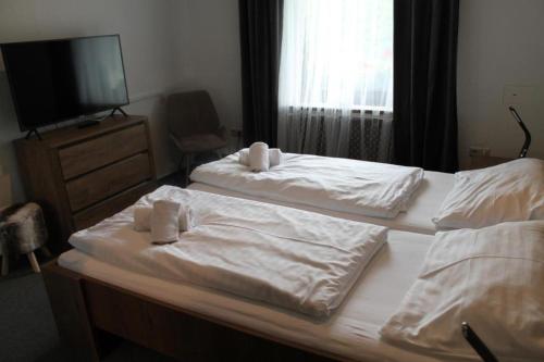 two beds in a bedroom with white sheets and towels at Draxlerhaus in Hohentauern