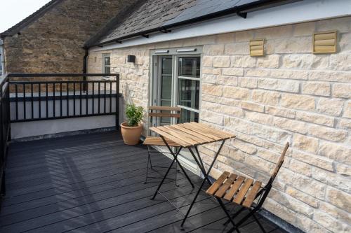 a wooden table and two chairs on a deck at 30 Chipping Norton - Luxury Holiday Apartments in Chipping Norton