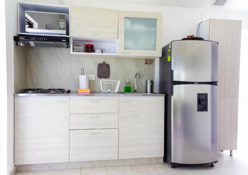 a stainless steel refrigerator in a kitchen with white cabinets at Casas Campestres Los Miradores de Fruworld in Carmen de Apicalá