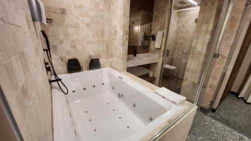 伊茲密爾的住宿－Barry Hotel，带淋浴的浴室配有白色浴缸。