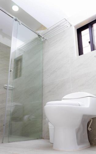a bathroom with a toilet and a glass shower at Casas Campestres Los Miradores de Fruworld in Carmen de Apicalá
