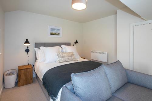a bedroom with a large bed and a couch at 30 Chipping Norton - Luxury Holiday Apartments in Chipping Norton