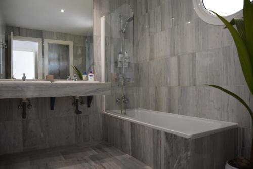 a bathroom with a shower and a sink and a tub at Mimosas Penthouse Marbella Cabopino in Marbella