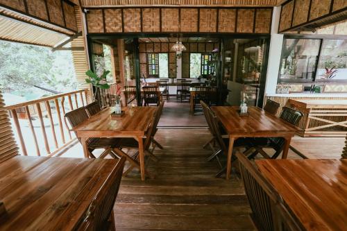 an empty restaurant with wooden tables and benches at Shepherds Ridge powered by Cocotel in Mabitac