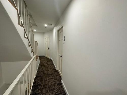 a hallway with white walls and a white door at The White Den Sukhumvit 44 in Bangkok
