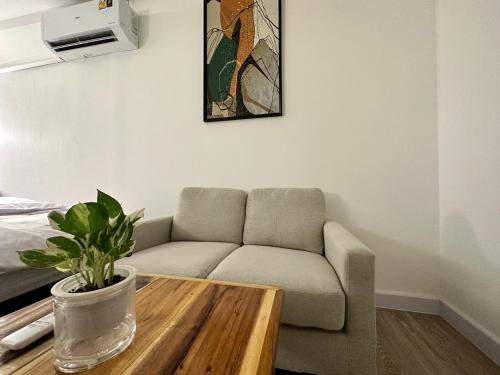 a living room with a couch and a coffee table at The White Den Sukhumvit 44 in Bangkok