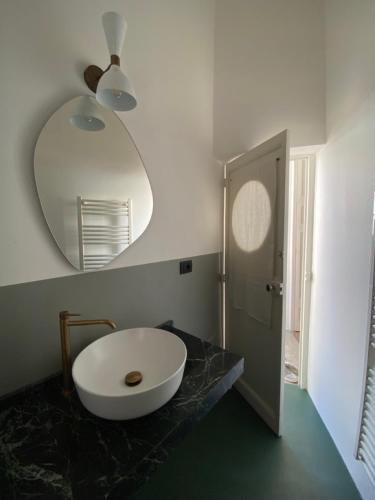 a bathroom with a large white sink and a mirror at Roiss Haus Suites in Lecce