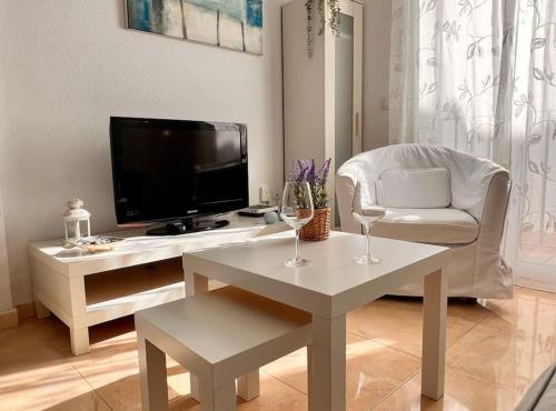 sala de estar con TV y mesa con copas de vino en SibsSanlucar Carril SanDiego Centro Familias Garaje, en Sanlúcar de Barrameda