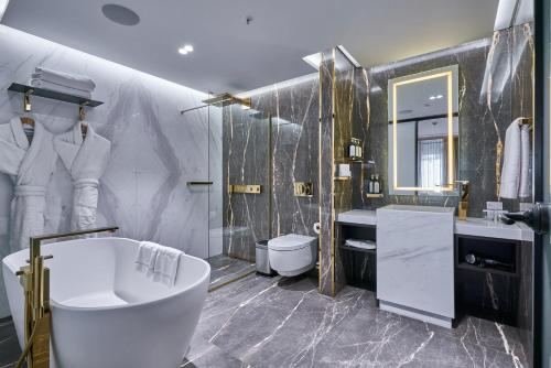 a bathroom with a tub and a toilet and a sink at Rayelin Hotel Istanbul Old City Special Category in Istanbul