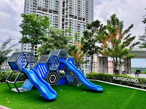Urban Suite Cozy Family Homestay at Georgetown by Heng Penang Homestay في Jelutong: ملعب في حديقة مع زحليقة زرقاء
