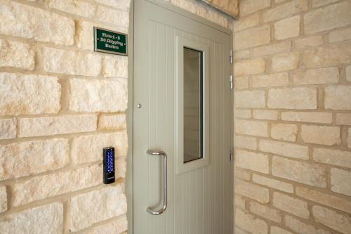 a door with a phone next to a brick wall at 30 Chipping Norton - Luxury Holiday Apartments in Chipping Norton