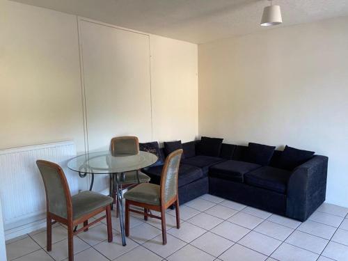 a living room with a couch and a table and chairs at Single and doubles rooms close to central London in London