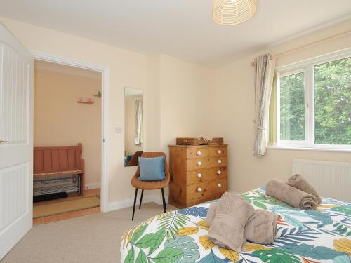 a bedroom with a bed and a dresser and a chair at Minack in Bude