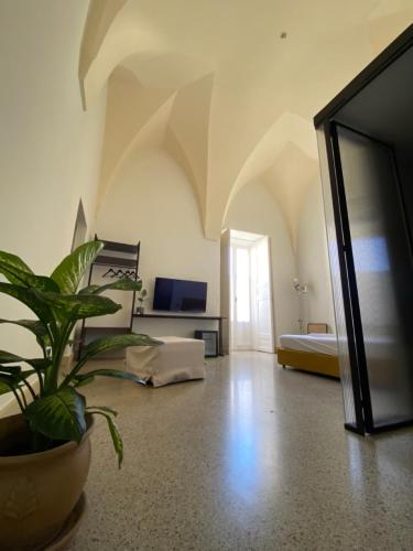a living room with a potted plant and a bedroom at Roiss Haus Suites in Lecce