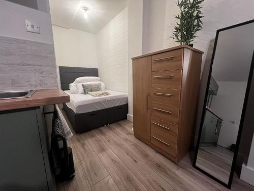 ein kleines Schlafzimmer mit einem Bett und einer Kommode in der Unterkunft Beddoes Court Top Floor Studio with Sea Views in Saundersfoot