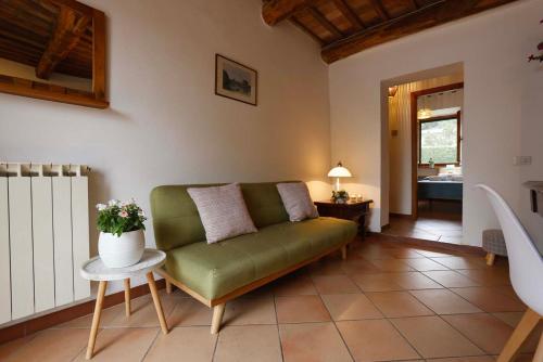 a living room with a green couch and a table at Agriturismo Casale le Crete in Acquapendente