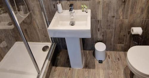 La salle de bains est pourvue d'un lavabo blanc et de toilettes. dans l'établissement Modern Peaceful 1-Bed Apartment Rutland Point, à Morcott