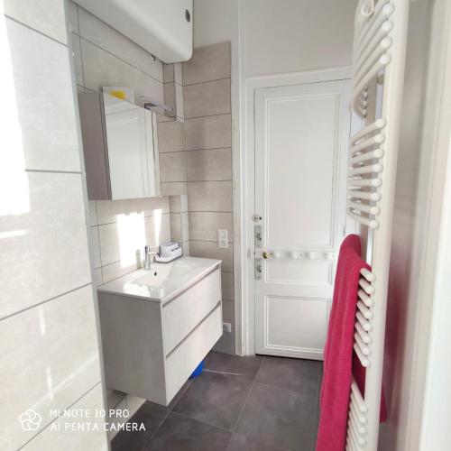 une salle de bain avec un lavabo et un miroir dans l'établissement LA REPOSEE, à Trouville-sur-Mer