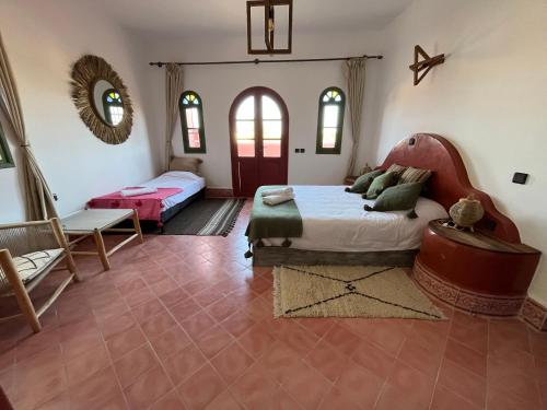 a bedroom with two beds and a mirror in it at Villa Nouran - Chambre Hôte in Ghazoua
