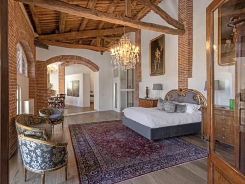 een slaapkamer met een bed en een kroonluchter bij La Casa dei Fortunati in Montemagno