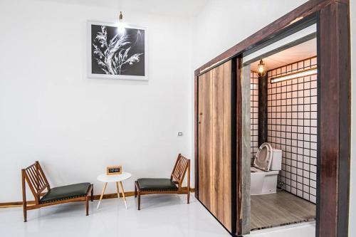 a room with two chairs and a table and a table and a door at Na Klongluang Boutique Resort in Ban Khlong Nung