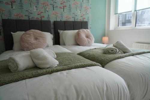 a bedroom with two beds with towels on them at Cosy 2 bedroom on Bromley-Lewisham Hospital Borders in Catford