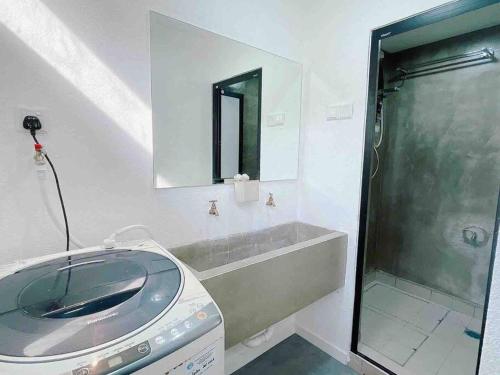 a bathroom with a sink and a shower with a mirror at Cheerful 27 Home with BBQ grill in Cheras