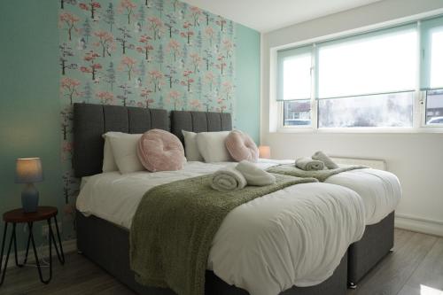 a bedroom with a large bed with towels on it at Our 2 bedroom house or borders of Bromley and Lewisham is available now! in Catford