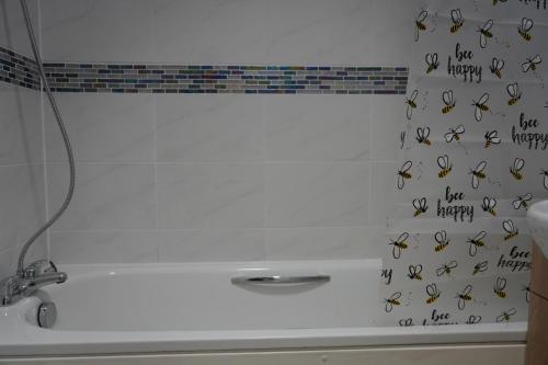 eine Badewanne mit einem Haufen Bienen an der Wand in der Unterkunft Our 2 bedroom house or borders of Bromley and Lewisham is available now! in Catford