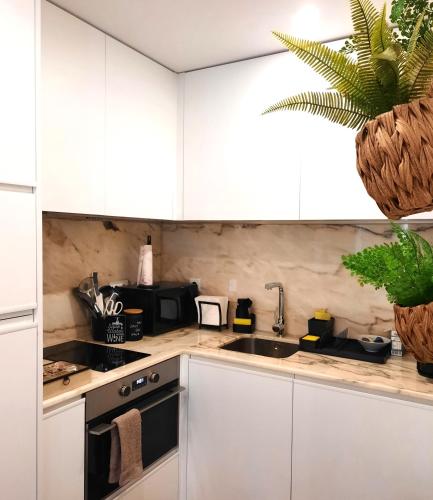 a kitchen with white cabinets and a sink at Smiling Places - Apartment in Porto in Porto